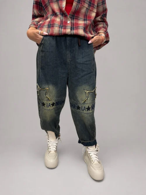 spodnie jeansowe STAR Denim z aplikacjami luźne spodnie jeansowe z gumką w pasie spodnie denim z gwiazdkami i przetarciami damskie spodnie jeansowe z dekoracyjną nogawką spodnie jeansowe z dekatyzowanym wykończeniem modne spodnie denim z nadrukiem na nogawce spodnie jeansowe o swobodnym fasonie spodnie STAR Denim Butik Madzia Fashion