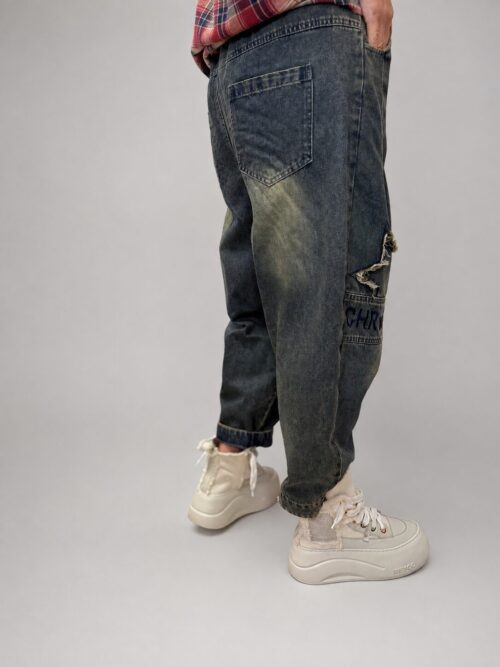 spodnie jeansowe STAR Denim z aplikacjami luźne spodnie jeansowe z gumką w pasie spodnie denim z gwiazdkami i przetarciami damskie spodnie jeansowe z dekoracyjną nogawką spodnie jeansowe z dekatyzowanym wykończeniem modne spodnie denim z nadrukiem na nogawce spodnie jeansowe o swobodnym fasonie spodnie STAR Denim Butik Madzia Fashion