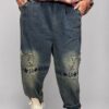 spodnie jeansowe STAR Denim z aplikacjami luźne spodnie jeansowe z gumką w pasie spodnie denim z gwiazdkami i przetarciami damskie spodnie jeansowe z dekoracyjną nogawką spodnie jeansowe z dekatyzowanym wykończeniem modne spodnie denim z nadrukiem na nogawce spodnie jeansowe o swobodnym fasonie spodnie STAR Denim Butik Madzia Fashion