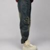 spodnie jeansowe STAR Denim z aplikacjami luźne spodnie jeansowe z gumką w pasie spodnie denim z gwiazdkami i przetarciami damskie spodnie jeansowe z dekoracyjną nogawką spodnie jeansowe z dekatyzowanym wykończeniem modne spodnie denim z nadrukiem na nogawce spodnie jeansowe o swobodnym fasonie spodnie STAR Denim Butik Madzia Fashion