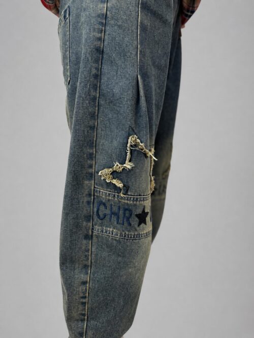 spodnie jeansowe STAR Denim z aplikacjami luźne spodnie jeansowe z gumką w pasie spodnie denim z gwiazdkami i przetarciami damskie spodnie jeansowe z dekoracyjną nogawką spodnie jeansowe z dekatyzowanym wykończeniem modne spodnie denim z nadrukiem na nogawce spodnie jeansowe o swobodnym fasonie spodnie STAR Denim Butik Madzia Fashion