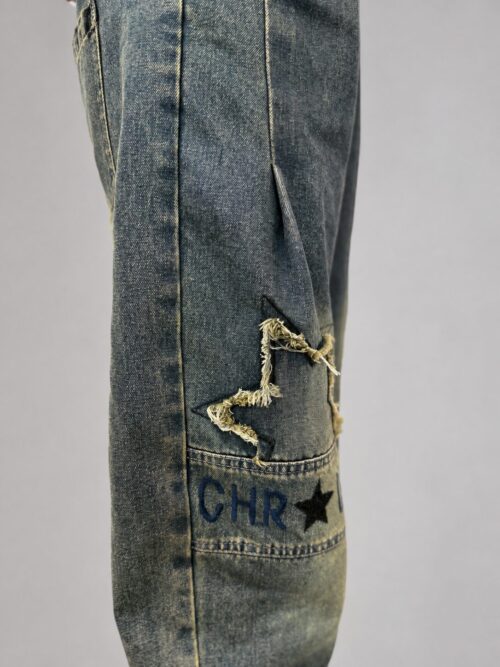 spodnie jeansowe STAR Denim z aplikacjami luźne spodnie jeansowe z gumką w pasie spodnie denim z gwiazdkami i przetarciami damskie spodnie jeansowe z dekoracyjną nogawką spodnie jeansowe z dekatyzowanym wykończeniem modne spodnie denim z nadrukiem na nogawce spodnie jeansowe o swobodnym fasonie spodnie STAR Denim Butik Madzia Fashion