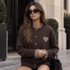 Kardigan damski czekoladowy z sercem Czekoladowy kardigan z kraciastymi detalami Kardigan damski z ozdobnymi guzikami Sweter rozpinany czekoladowy z sercem Kardigan z kraciastą falbanką przy dekolcie Czekoladowy sweter damski na guziki
